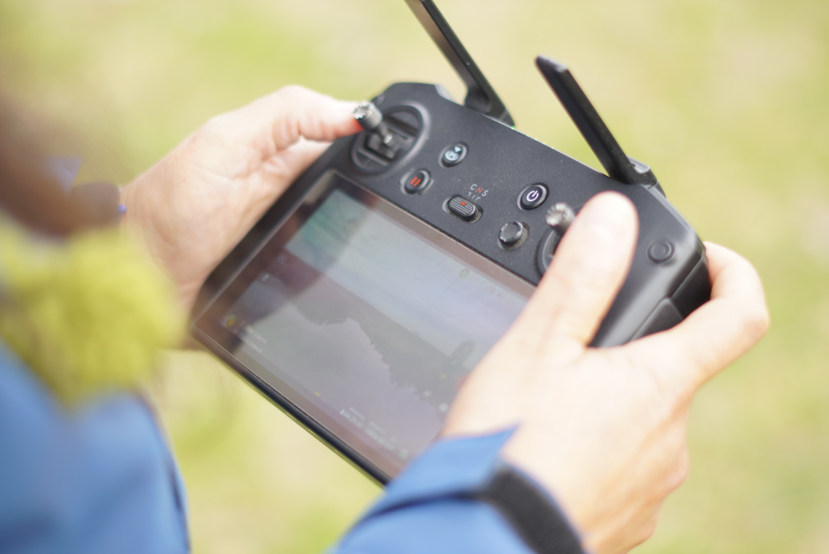 Alumno del curso DRONECAP practicando el manejo de control remoto de dron al aire libre en la Región de Los Lagos